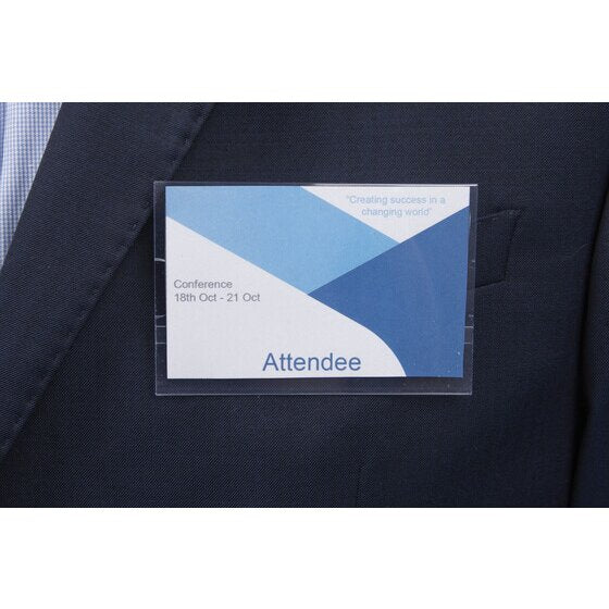 Rexel large clear card holder worn on a navy jacket lapel, holding a blue and white sample conference card reading Attendee