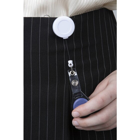 Rexel white retractable reel clipped at the waistband of pinstripe trousers, with a hand drawing out the cord and strap holding a blue fob