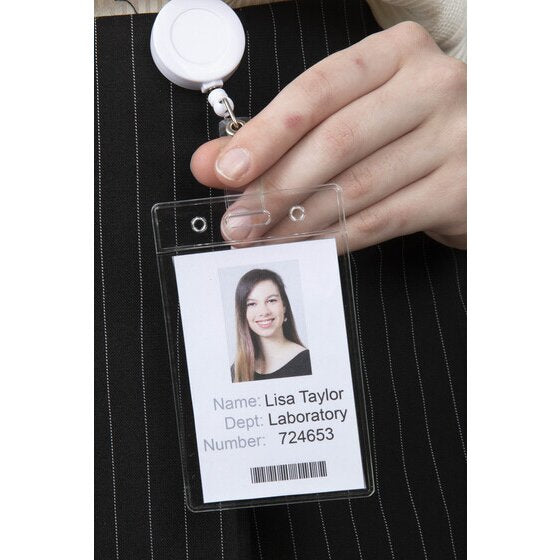 Clear Rexel soft portrait pouch clipped to a white badge reel and held out by the wearer, showing a sample staff card with photo and barcode