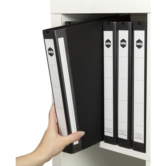 A hand lifting a black Marbig 5073002 A4 ring binder from a white cabinet with three more black binders standing beside it showing white spine labels.