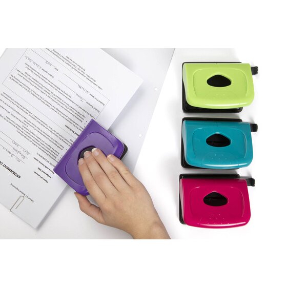 Hand pressing a purple two hole punch on a printed sheet, beside lime, teal and pink punches seen from above