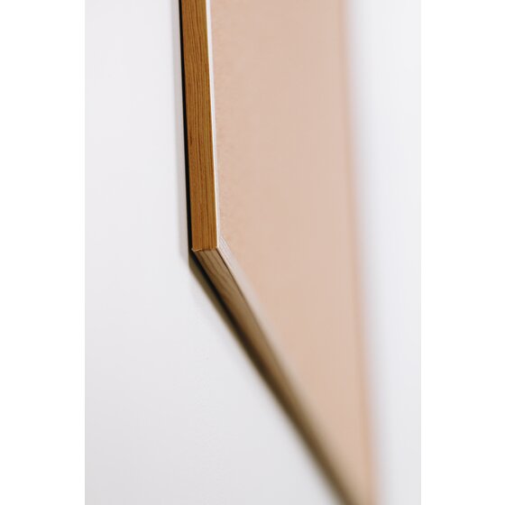 Side view of the pine finish frame edge on a Quartet corkboard, photographed at an angle against a white wall