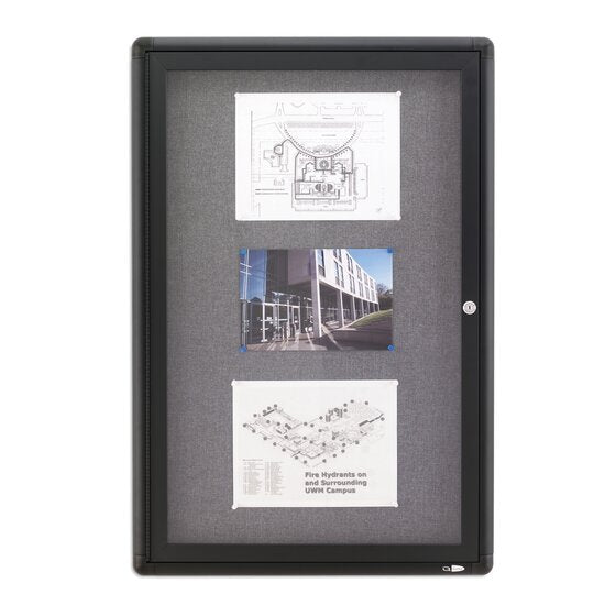 Portrait Quartet enclosed board with grey fabric behind a dark framed door, holding a site plan, a photograph of a modern building and a campus map, with a lock on the right edge
