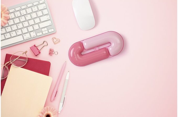 Pink desk organizer with stationery items on a pink background