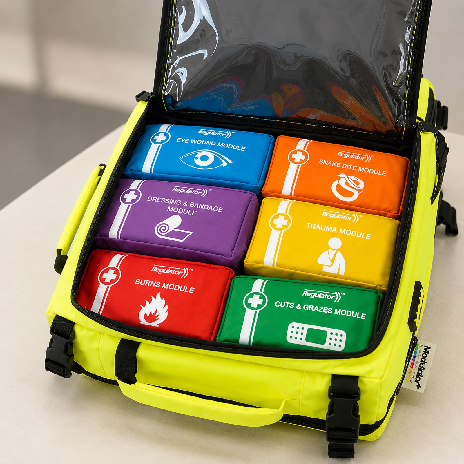 Close up view inside the open AeroKit Modulator Guardian First Aid Kit Backpack showing six colour coded modules for eye wounds, snake bites, dressings and bandages, trauma, burns, and cuts and grazes.