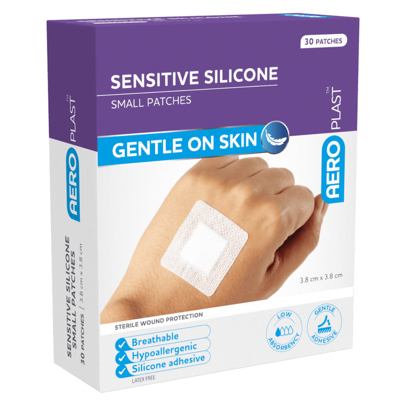 Angled front view of AeroPlast Sensitive Silicone Small Patches box showing the square dressing applied to a hand and gentle on skin product positioning.