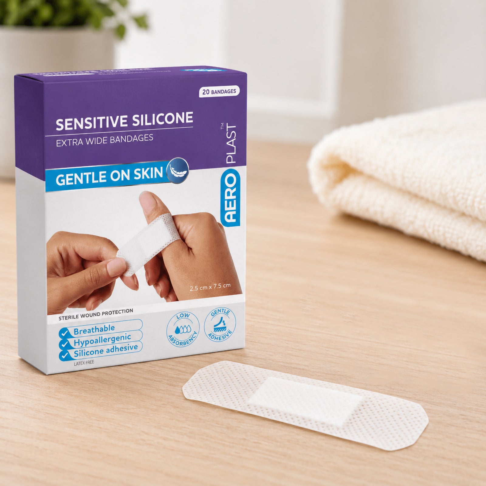 AeroPlast Sensitive Silicone Extra Wide Bandages box displayed beside an individual white dressing, presenting the 20 bandage pack and gentle skin protection format in a clean first aid setting.