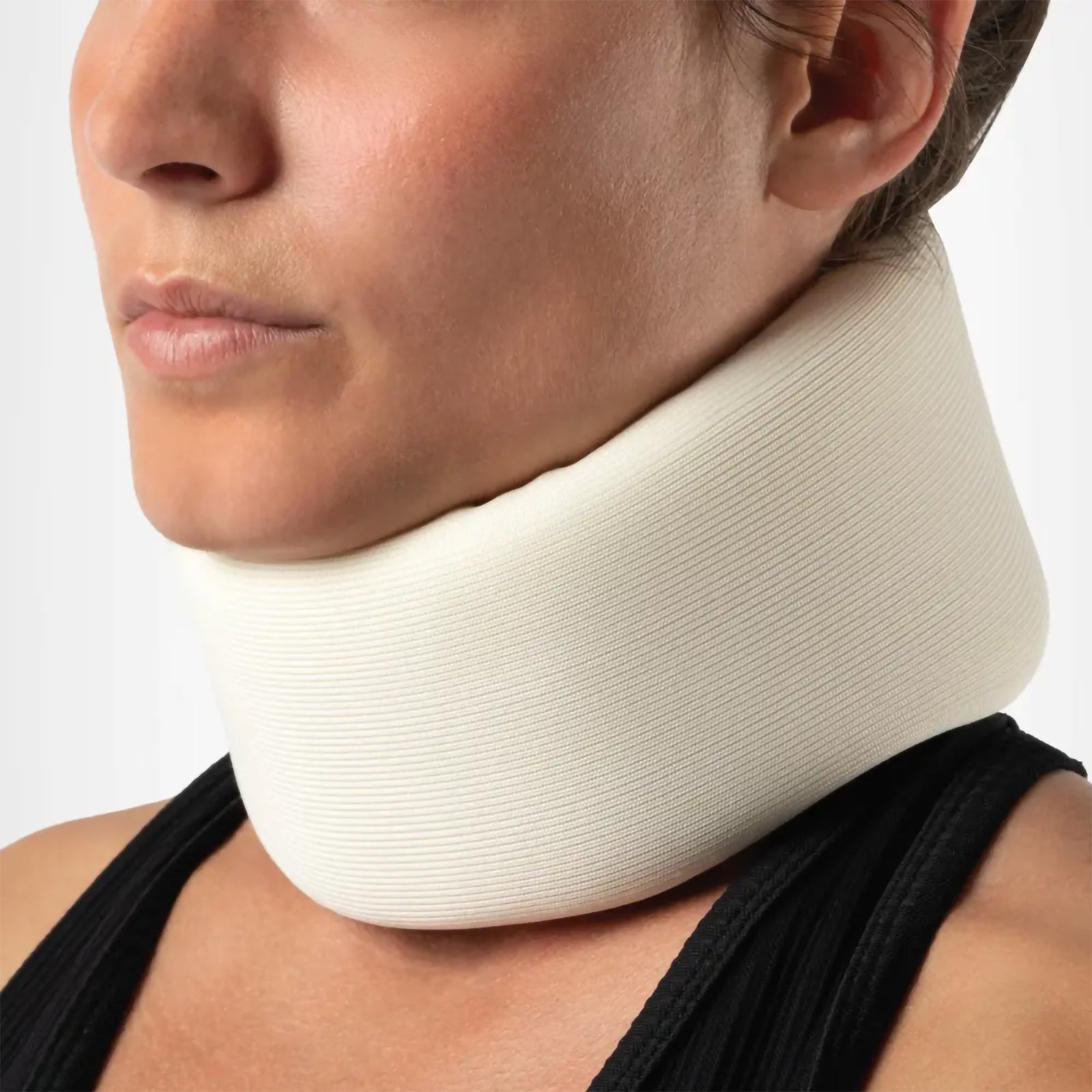 Detailed close up of the Large AeroSupplies Foam Cervical Collar being worn. The image highlights the fine textured foam surface, contoured upper edge beneath the chin and broad neck coverage, providing a clear view of the collar construction and supportive fit.