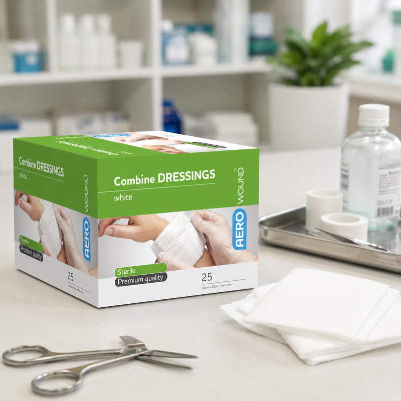 AeroWound Combine Dressings box displayed in a clean healthcare environment alongside white dressings, medical scissors, fixation tape and clinical supplies. The packaging identifies the product as sterile premium quality combine dressings in a 10 x 10cm size, with 25 dressings supplied per box for professional and first aid wound care.