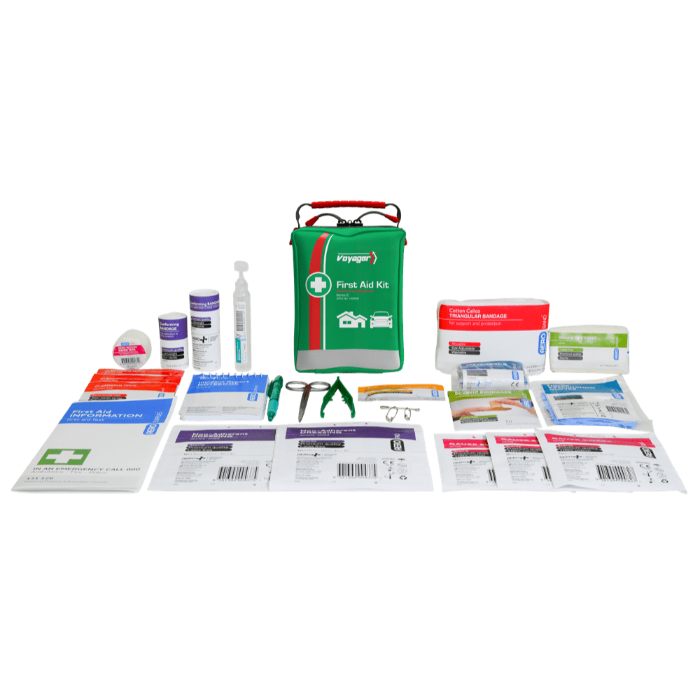 The green soft pack standing behind its contents laid out in rows, including bandages, dressings, plastic strips, gloves and eyewash
