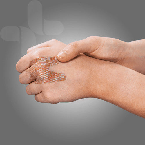 A knuckle shaped fabric bandage in place across the knuckle of a closed hand