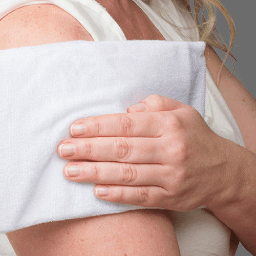 A person holding a gel pack in its towelling cover against the top of their shoulder