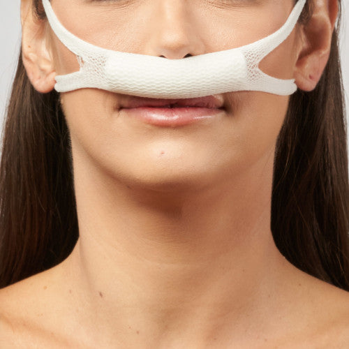 A front view of the same nasal sling bandage in place under the nose