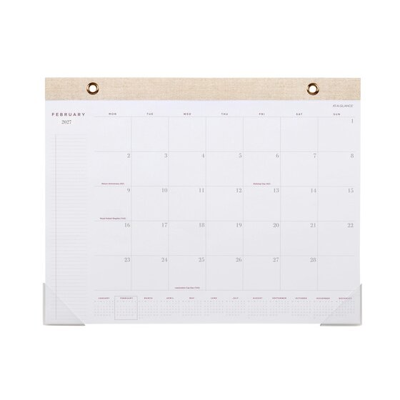 At-A-Glance AAG100127 desk pad open at February 2027 with a linen look headband and two grommets, Monday to Sunday columns, plain day blocks and a month strip along the foot.