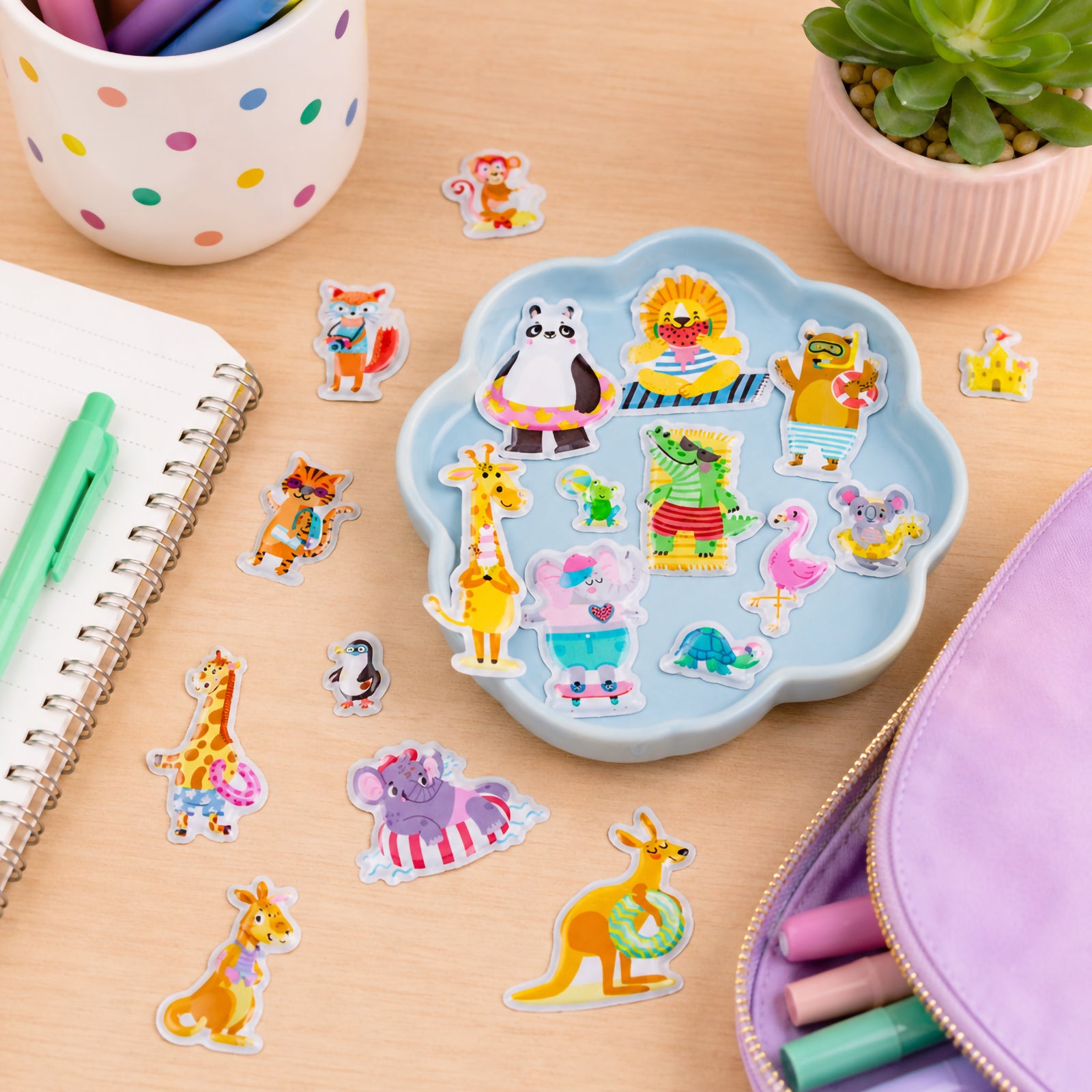 Assorted Beach Buddies puffy stickers displayed in a tray alongside stationery supplies. The collection showcases playful animal friends enjoying sunny holiday adventures, swimming, relaxing and exploring colourful beach scenes.