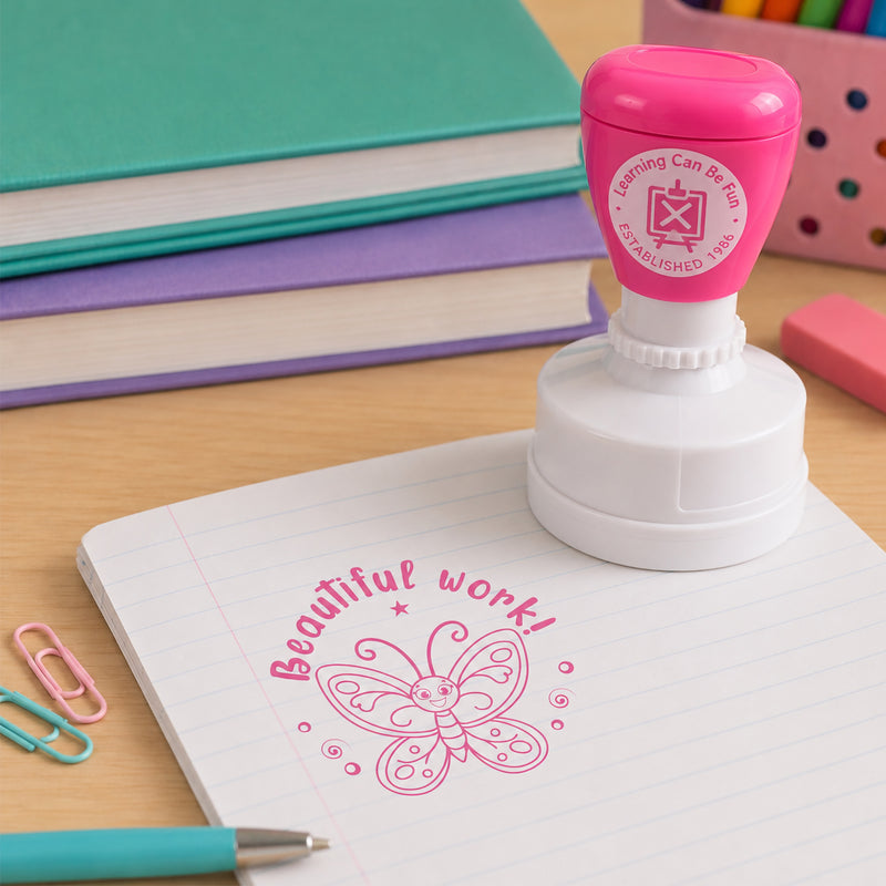 Beautiful Work merit stamp positioned beside colourful stationery and notebooks on a classroom desk. The butterfly themed stamp offers positive recognition for students who demonstrate effort, care and attention to detail.