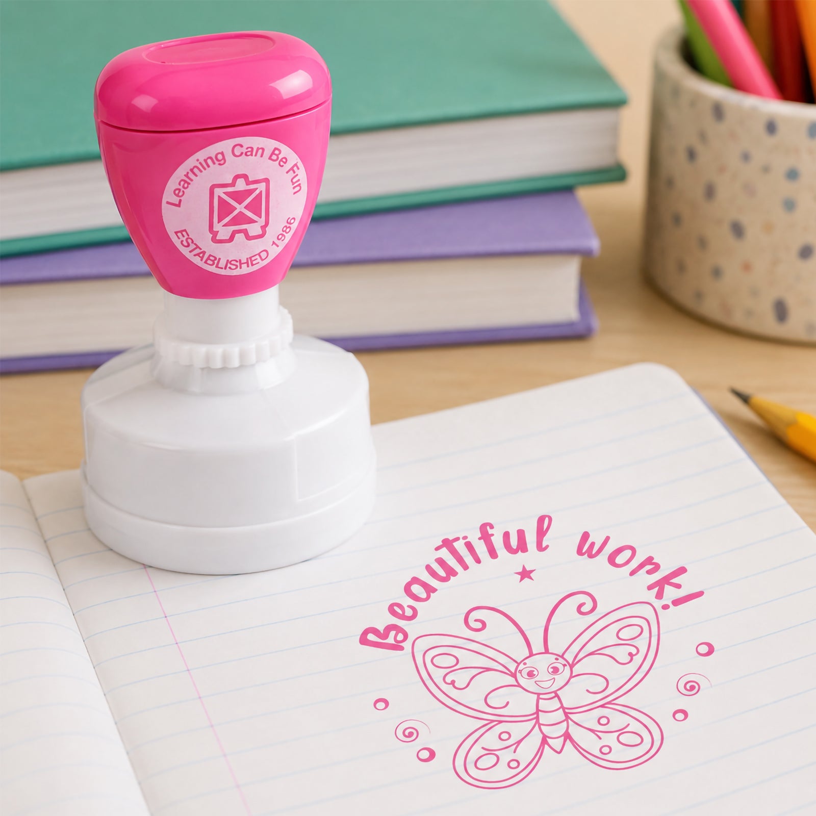 Learning Can Be Fun Beautiful Work self inking merit stamp displayed on an open exercise book. The bright pink butterfly design creates a cheerful reward impression that celebrates neat presentation, creativity and classroom achievement.