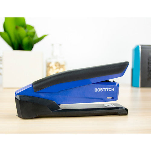 Blue and black Bostitch InPower stapler on a wooden desk in front of a pot plant and a jar of pins