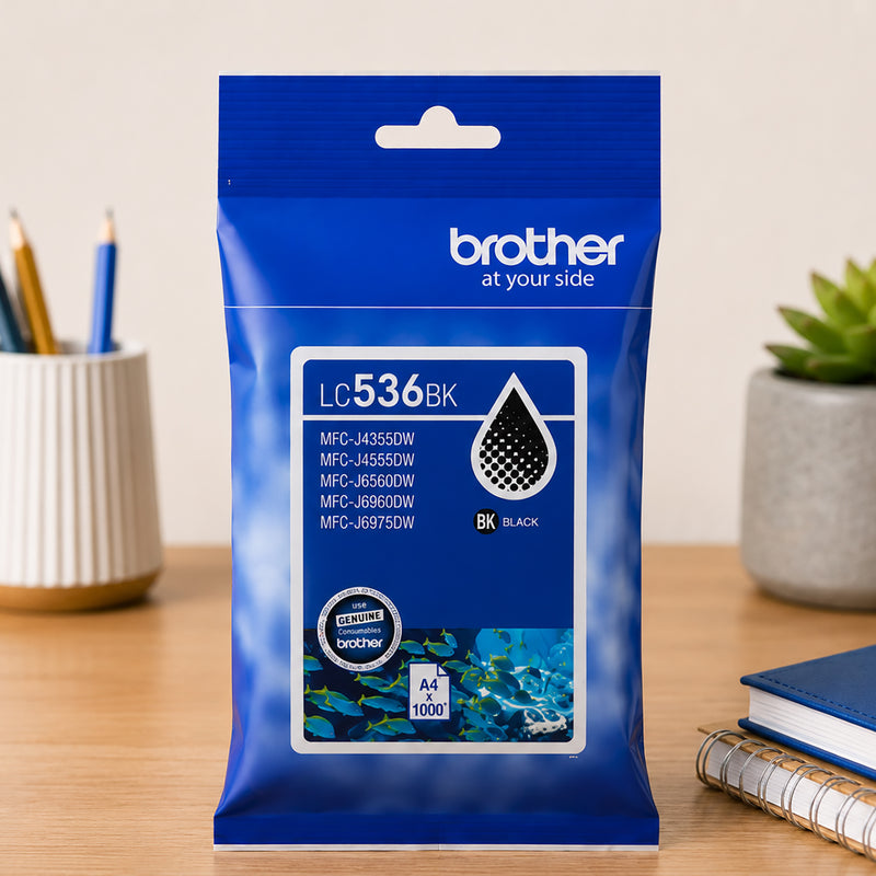 Front facing product display of the Brother LC536BK Black Ink Cartridge on a tidy desk with office accessories. The packaging clearly shows compatibility information, genuine Brother branding and page yield details, emphasising dependable printing performance.