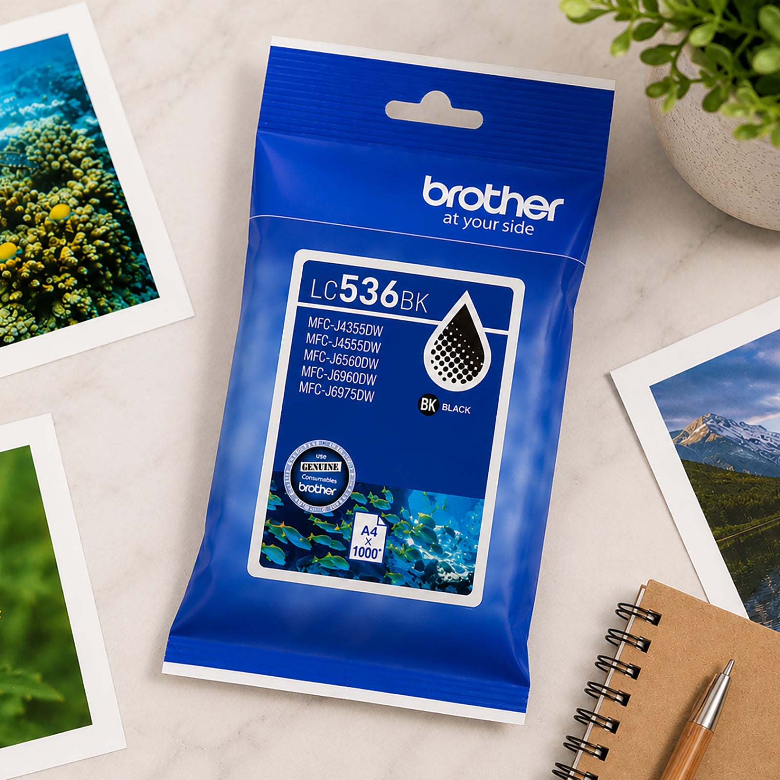 Top down workspace scene featuring the Brother LC536BK Black Ink Cartridge surrounded by printed photographs, stationery and notebooks. The composition showcases the cartridge as a reliable choice for everyday document printing, organisation and productivity tasks.