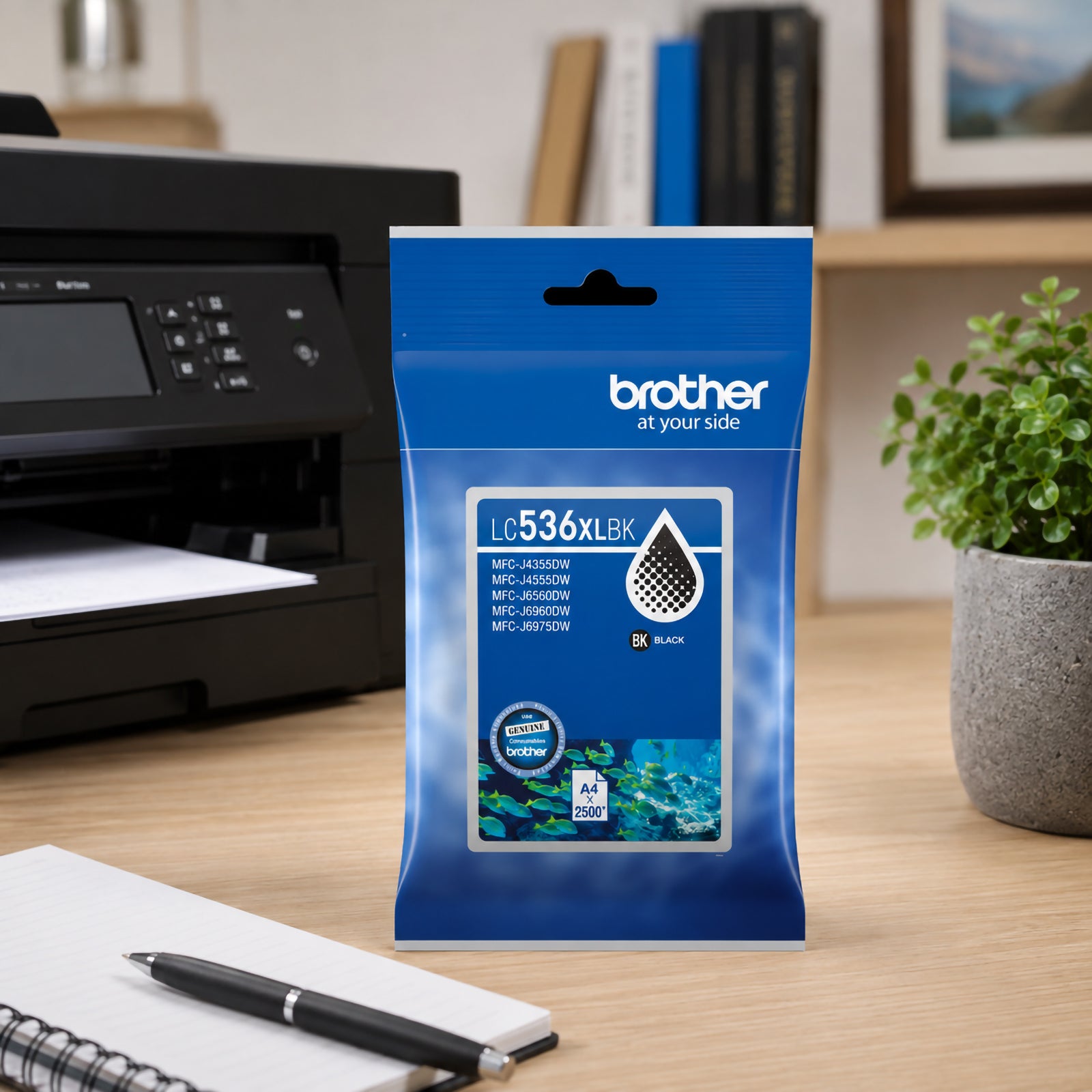 Lifestyle office image featuring the Brother LC536XLBK genuine black ink cartridge positioned next to a Brother printer with printed reports emerging from the output tray. A pen holder, desk accessories and a potted plant complete the professional setting. The scene showcases reliable document printing performance and the cartridge's suitability for busy workplaces and home offices.