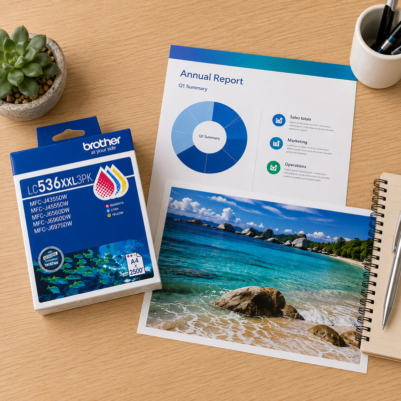 Top down office desk scene featuring the Brother LC536XXL3PK colour ink cartridge pack beside a printed annual report, colourful photo print, notebook and desktop accessories. The image showcases the cartridge pack's suitability for producing vivid graphics, reports and marketing materials.