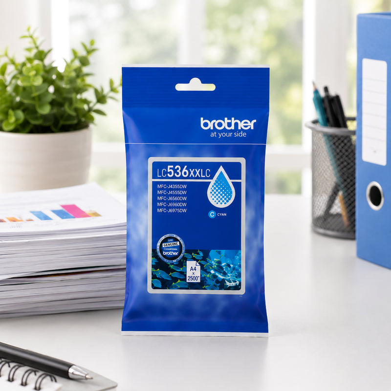 Front facing display of the Brother LC536XXLC super high yield cyan ink cartridge package on a modern office desk with printed reports, stationery and filing materials in the background. The image emphasises genuine Brother consumables designed for professional printing applications.