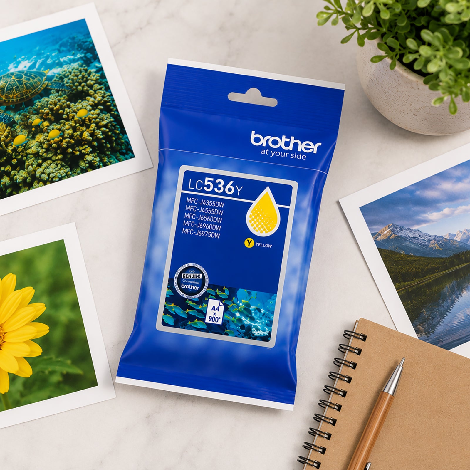 Overhead view of the Brother LC536Y Yellow Ink Cartridge surrounded by colourful printed photographs, a notebook and desktop accessories. The scene showcases the cartridge's ability to deliver bright, accurate yellow tones for photography, creative projects and high quality colour documents.