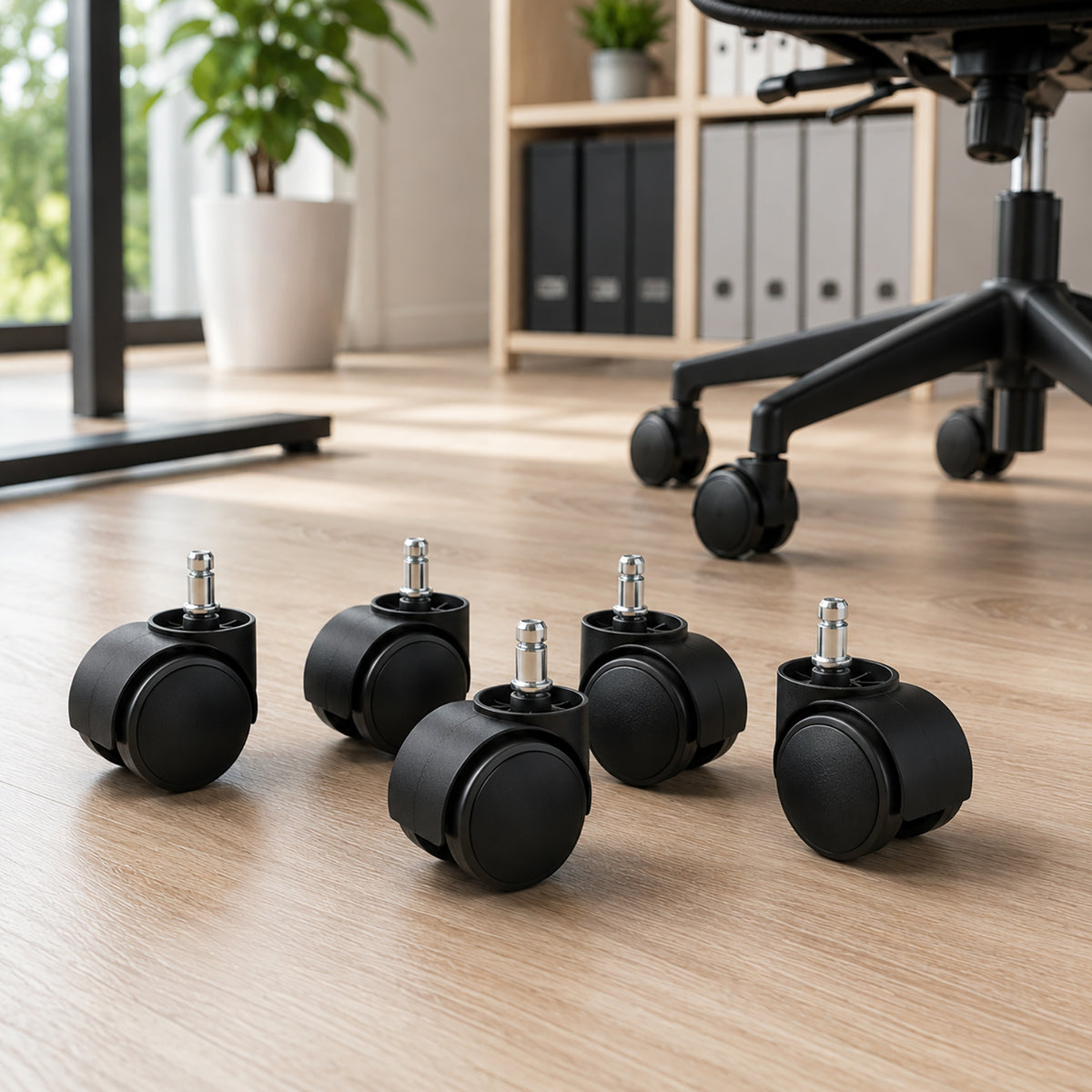 Five Buro 60mm twin wheel office chair castors arranged on a timber office floor, showing black wheel bodies and metal mounting stems with a compatible office chair visible in the background.
