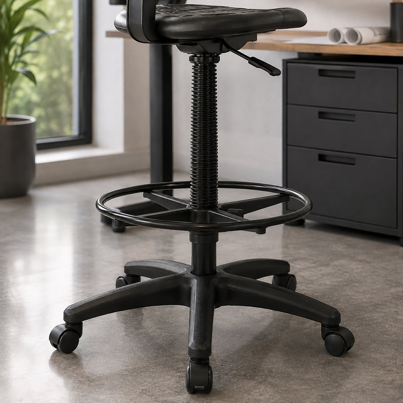 Close lifestyle view of the Buro Enso drafting setup highlighting the 270mm tall gas lift, circular black foot ring and five star mobile chair base beneath an elevated workstation in a modern professional environment.