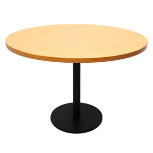Rapidline Estilo 1200mm round table with a beech top on a black column and flat disc base, viewed from slightly above