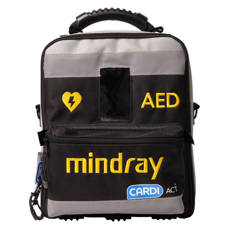 Front view of the CardiAct Mindray Soft Carry Case against a white background. The black and grey case features a reinforced top handle, yellow heart and AED markings, prominent Mindray branding, CardiAct identification, clear information window and front zip compartment for organised AED transport and storage.