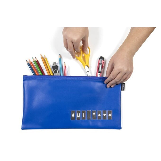Hands packing coloured pencils, scissors and a USB stick into a blue Celco name pencil case with AMITY spelt in the front strip