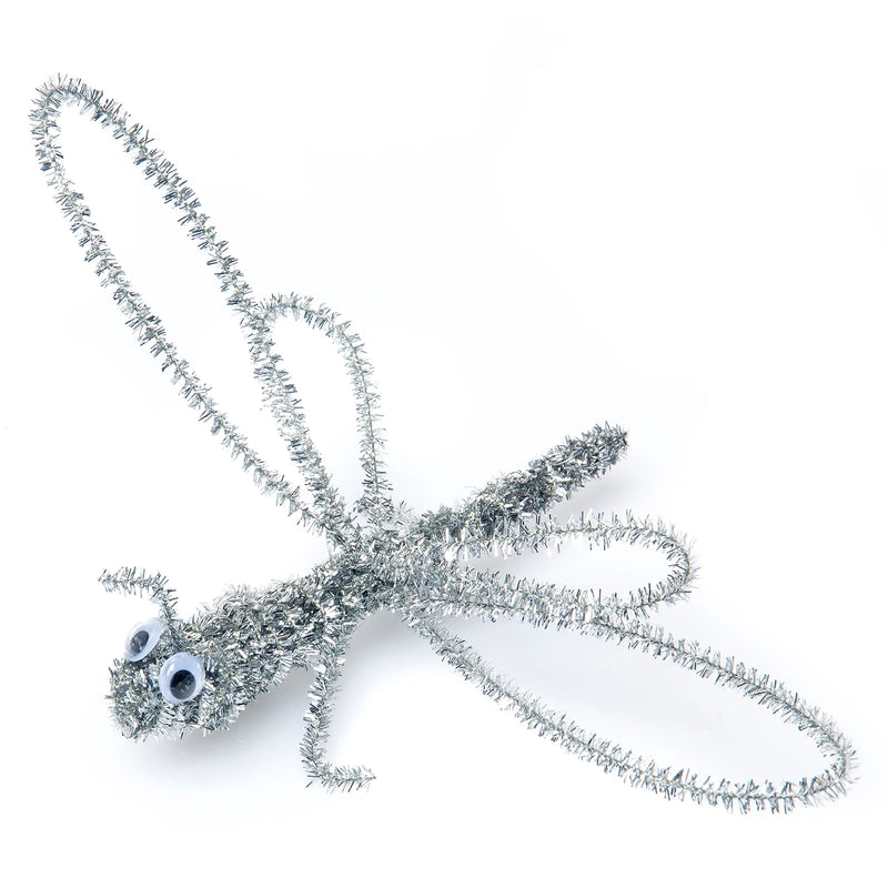 Silver tinsel chenille stem shaped into a dragonfly with googly eyes against a plain background. The detailed design demonstrates the flexibility and sculpting potential of the metallic stems for creating insects, animals and imaginative three dimensional models.