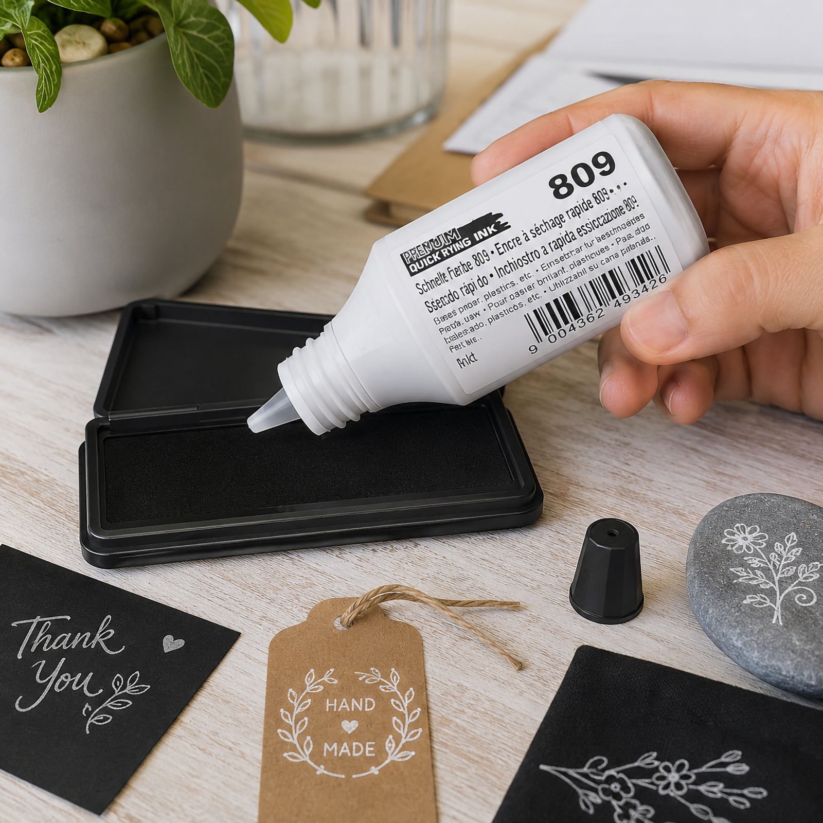 Hand applying genuine Colop 809 Quick Drying Ink Premium White 25ml onto a felt stamp pad using the precision nozzle, demonstrating controlled ink refilling for clean and consistent stamp performance on professional and craft projects.
