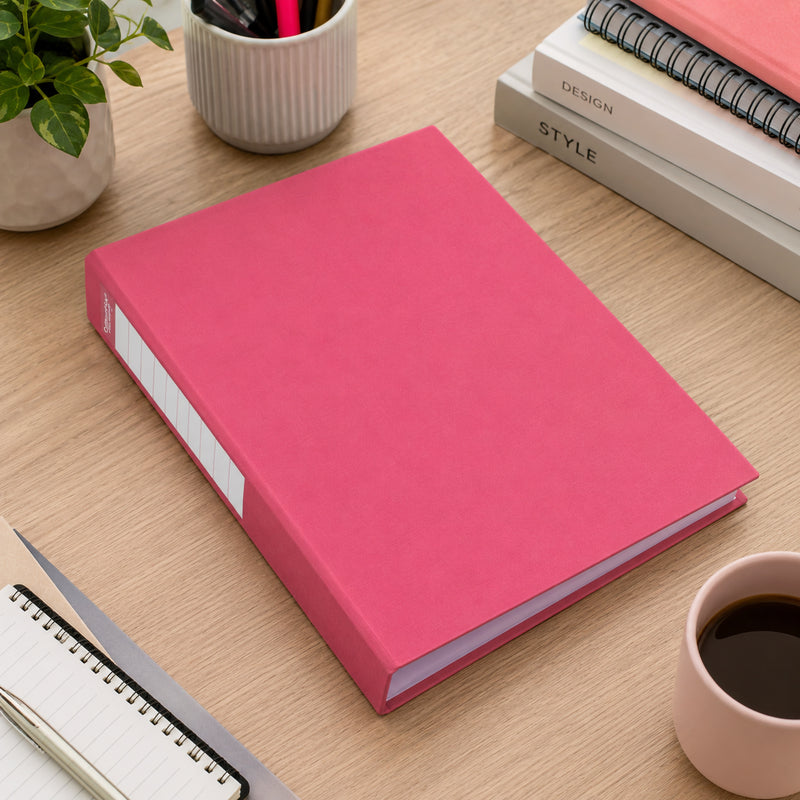 Illustrative desk scene from our earlier listing: a pink binder lying flat on a timber desk next to a coffee cup and notebooks
