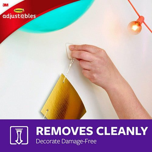 Hand pressing a Command hook onto a smooth tile surface