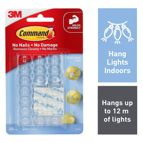 Close-up of a clear Command decorating clip attached to a painted wall holding fairy lights