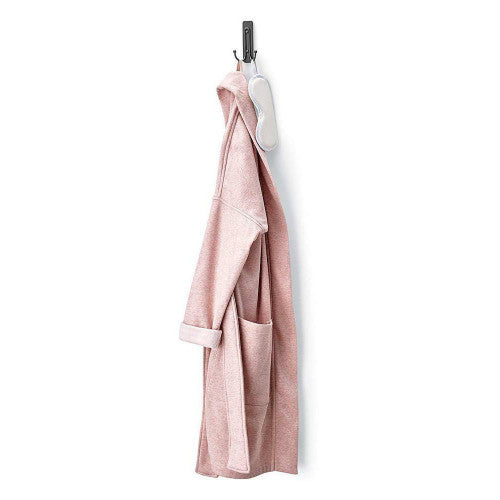 Command hook applied to a tiled bathroom wall holding a towel