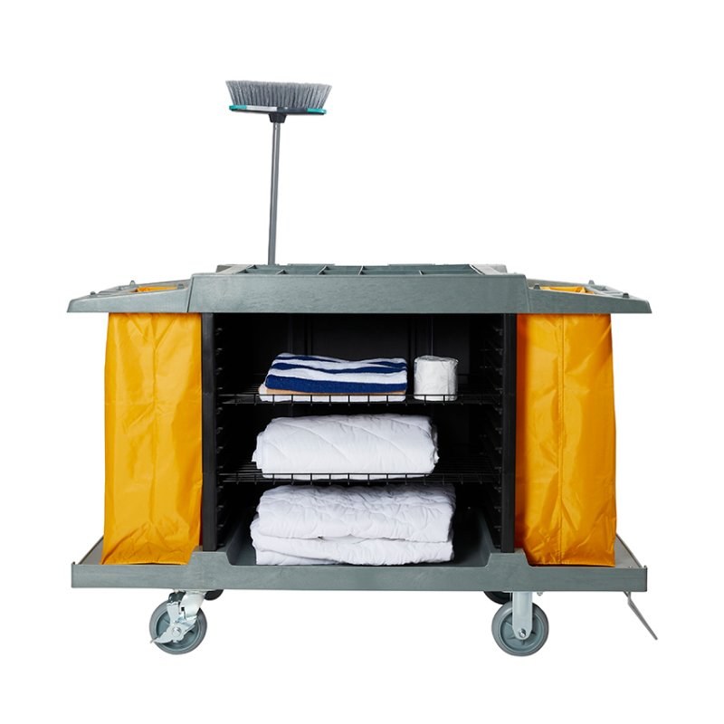 Compass 722430 trolley stocked with folded linen and toilet rolls on its wire shelves, a broom held upright on a pole at the back