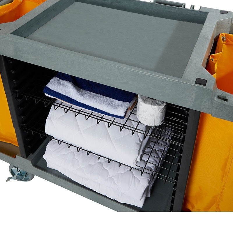 Close view of the plain grey top tray of the Compass 722430 trolley above the wire shelves holding towels and folded linen