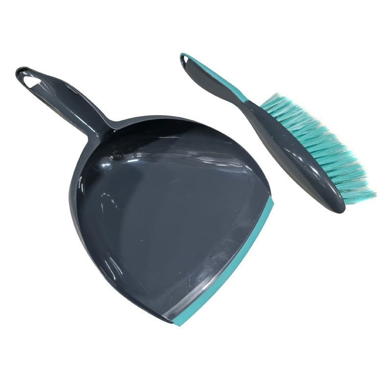 Compass dustpan lying flat beside its brush, showing the hanging hole in the pan handle and the soft aqua rubber lip