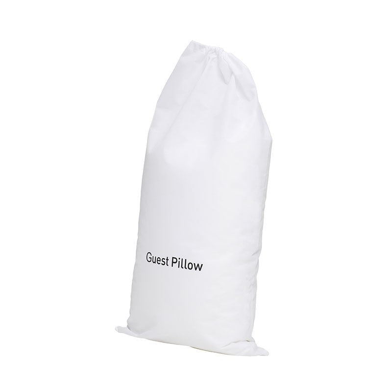 Compass white non-woven guest pillow bag, tall and filled, printed Guest Pillow near the base with the drawstring gathered at the top