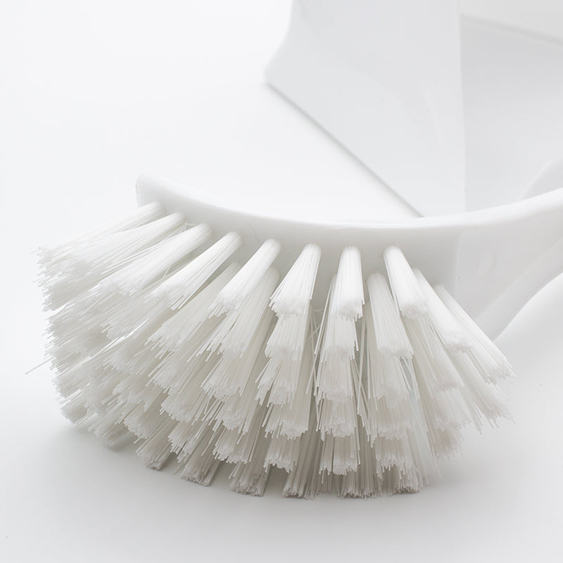 Close-up of the white curved brush head with white bristles fanned round its outer edge
