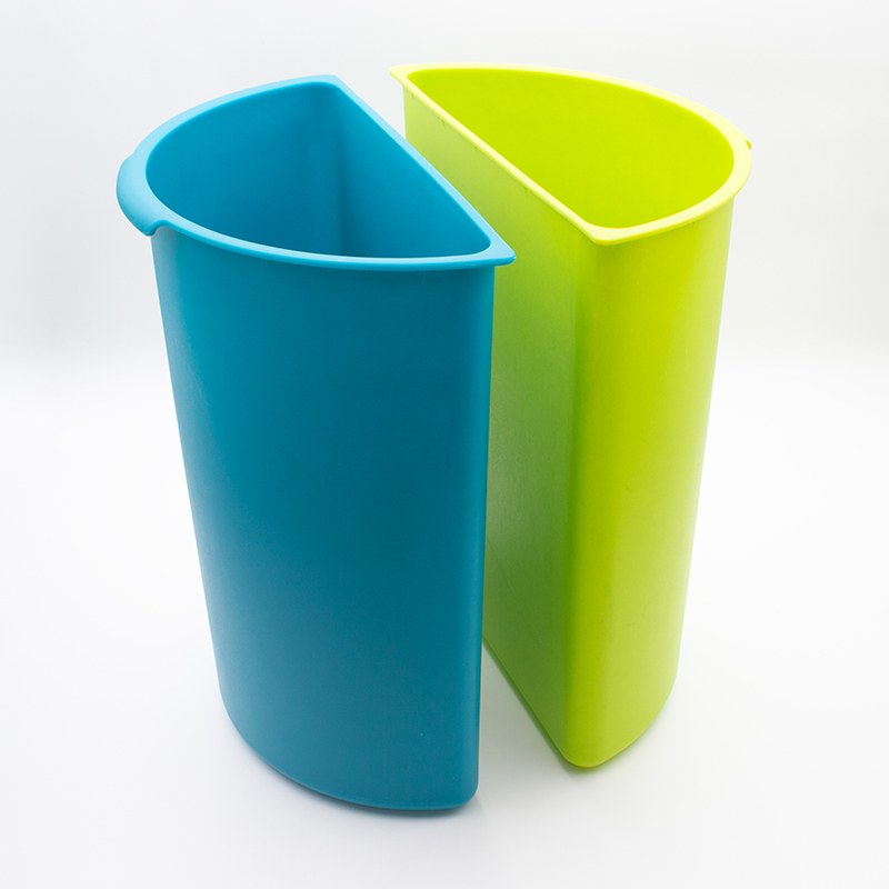 The two half round plastic inserts of the Compass round dual chamber bin standing side by side, one teal blue and one lime green