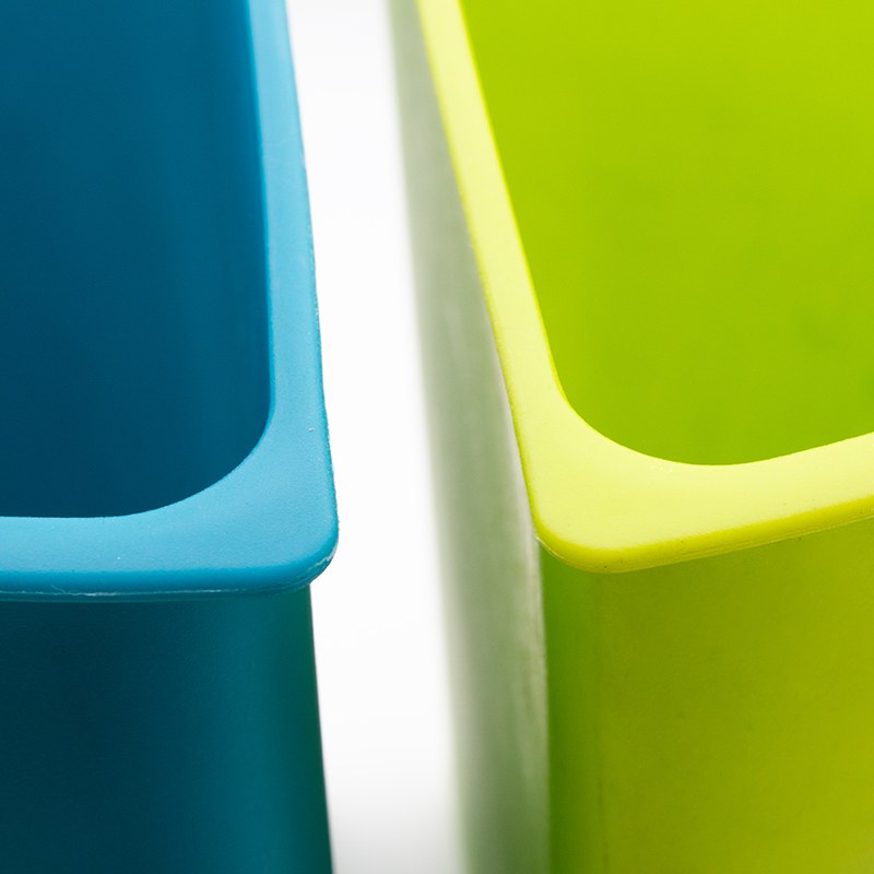 Close view of the rims of the teal blue and lime green inserts of the Compass round dual chamber bin