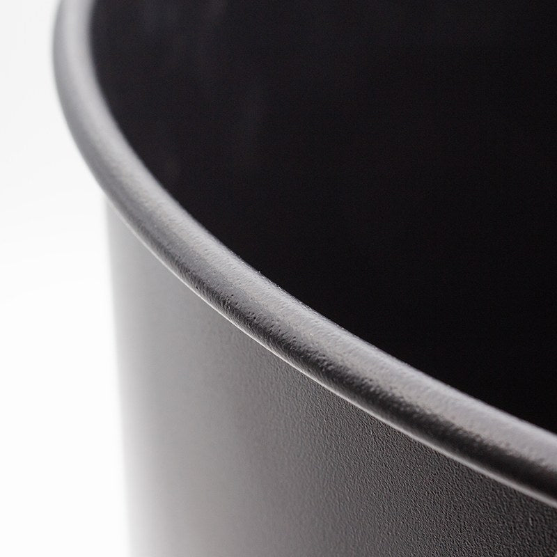Close view of the rolled top edge of the black powder coated shell of the Compass round bin