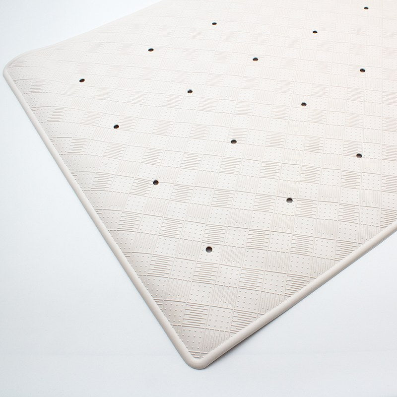Top surface of the large Compass bath mat at an angle, showing the raised checkerboard pattern and evenly spaced drain holes