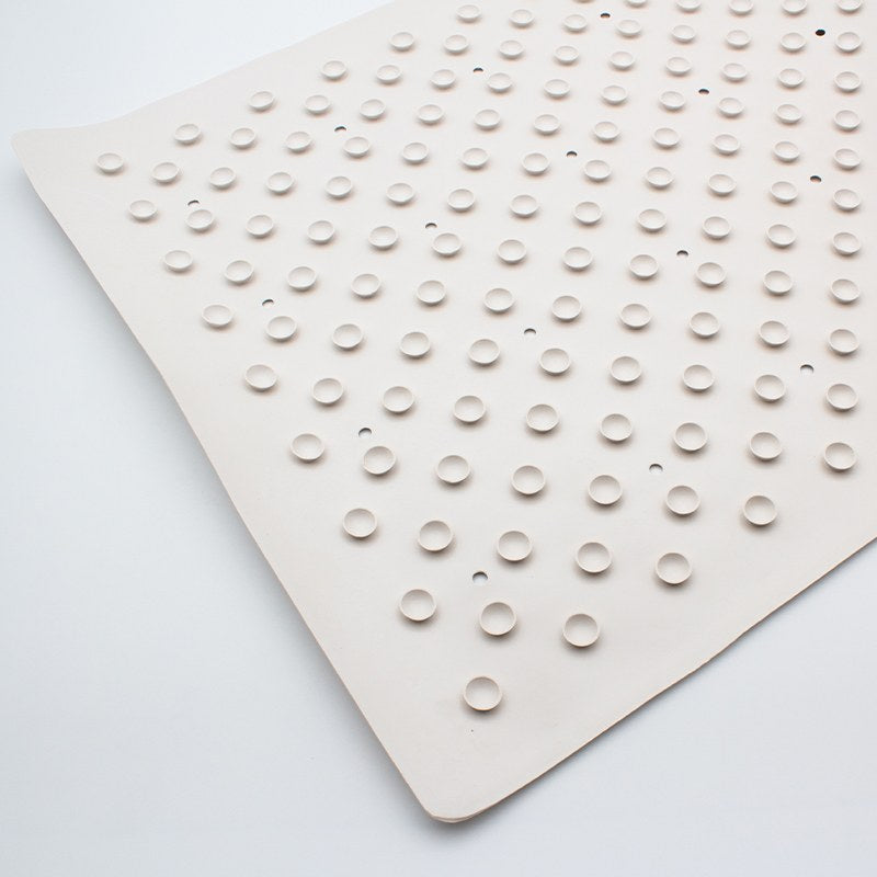 Underside of the large Compass rubber bath mat covered in rows of small round rubber cups with drain holes between them