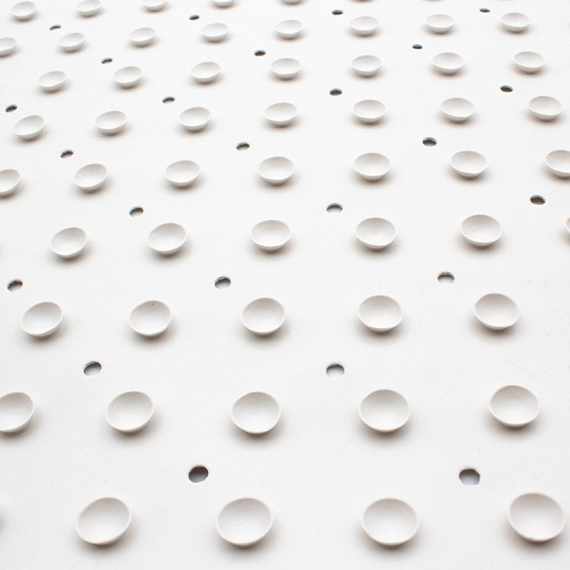 Macro view of the round rubber cups and small drain holes on the underside of the Compass large bath mat